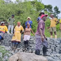 Group of people sitting on a gabion wall