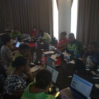 People sat around a large table working on laptops