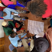 People gathering around a hand written poster during a workshop 